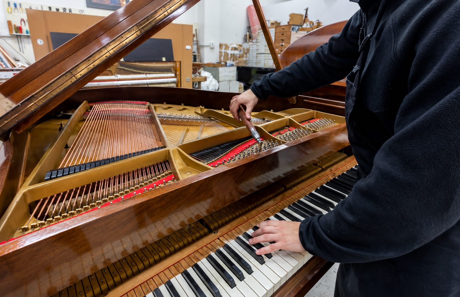 Accordeur Piano Service au travail sur un piano à queue